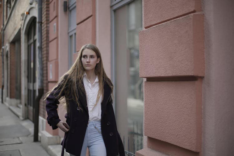 Woman Walking Near Concrete Wall