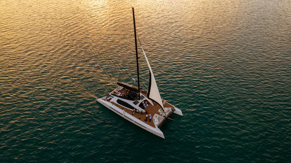 Aerial view of a catamaran sailing at sunset off the coast of Bermuda. - Barbados Nightlife for Couples: Romantic Bars and Sunset Cruises