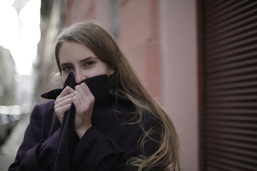 Woman Wearing Violet Coat While Covering Her Face With Her Hands