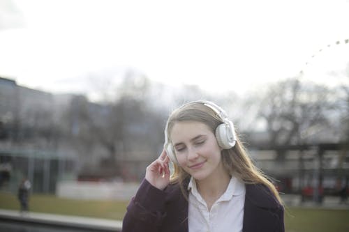 Shallow Focus Photo of Woman Wearing White Headphones