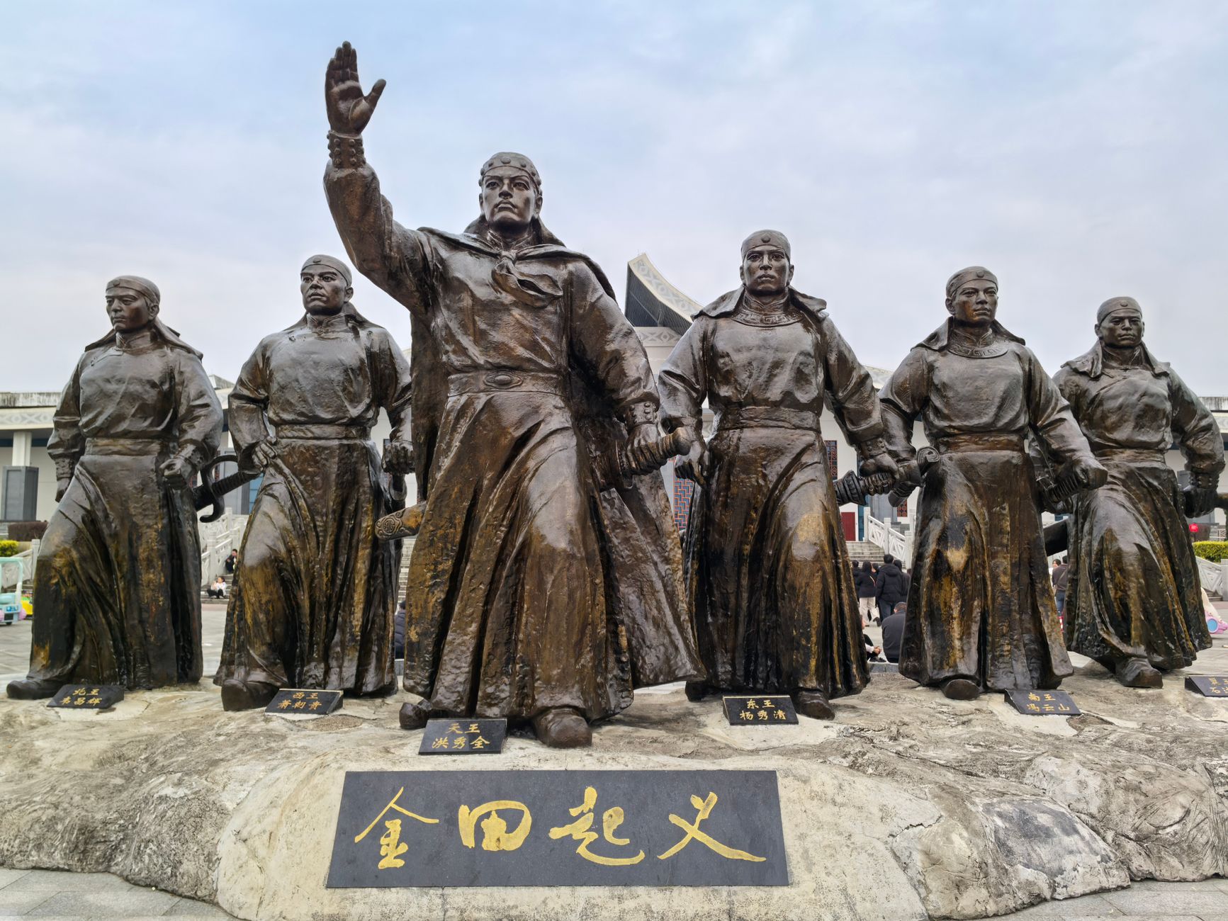 Bronze statues of historical leaders in revolutionary attire, symbolizing unity and strength.