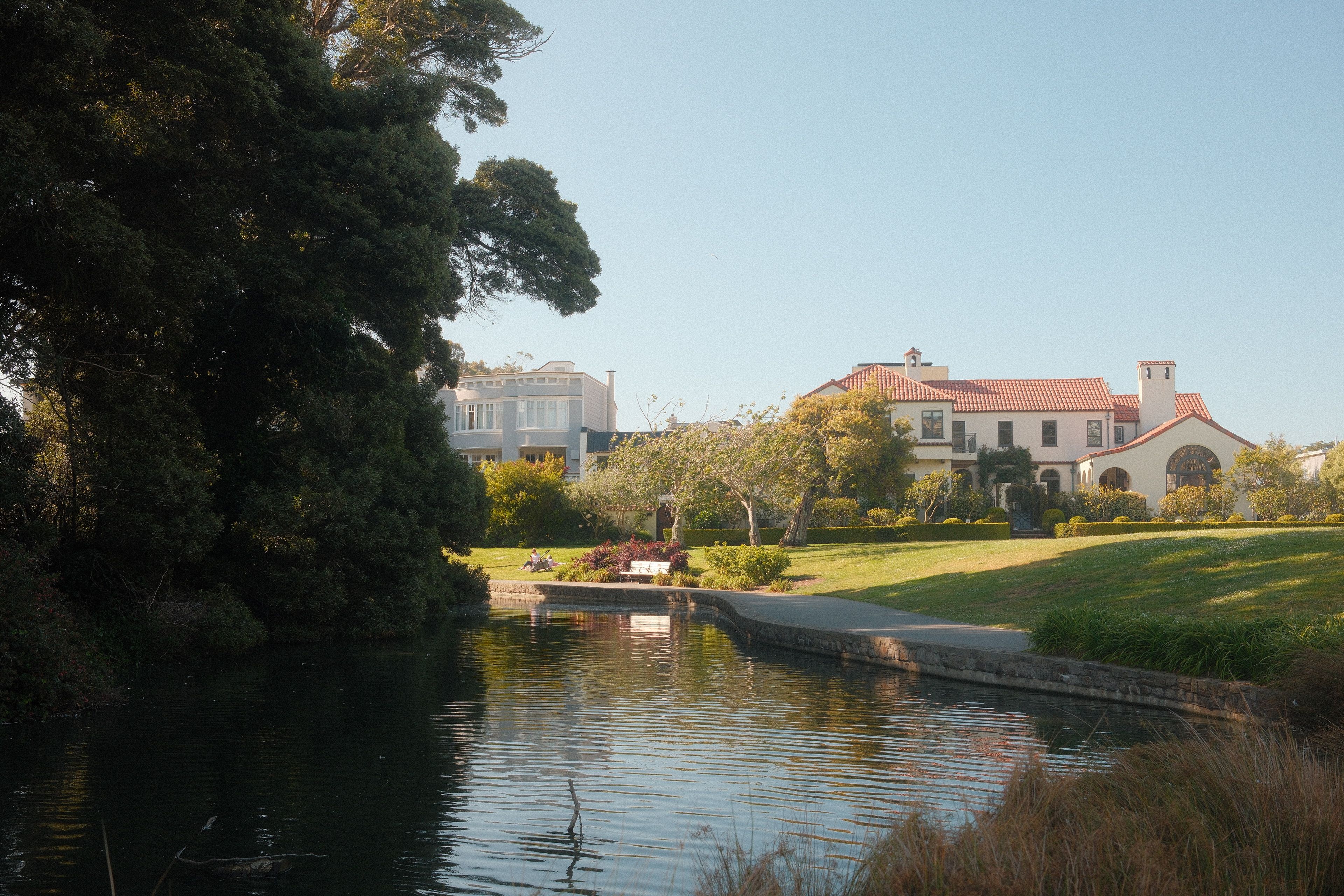 Beautiful house by a lake with lush greenery in San Francisco, CA.
