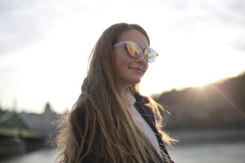Mor Ceketli Kadın Gümüş çerçeveli Havacı Güneş Gözlüğü Takıyor