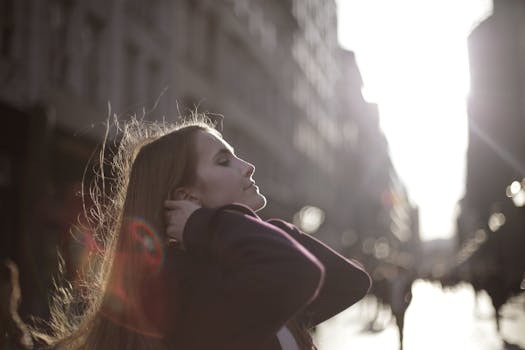 城市街道上，一个女人侧身享受着阳光