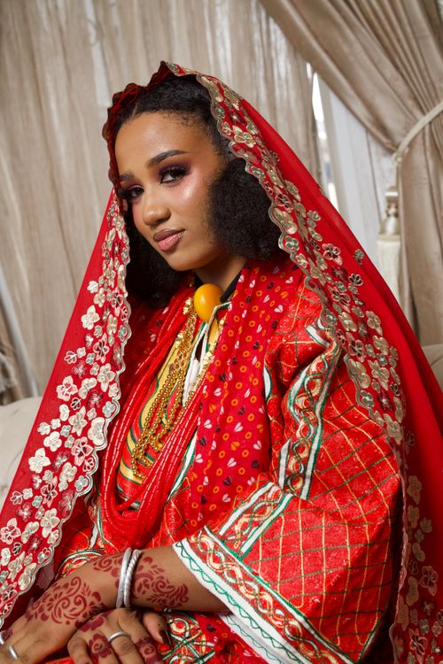Free Portrait of a beautiful Nigerian bride in vibrant traditional attire with intricate henna design. Stock Photo