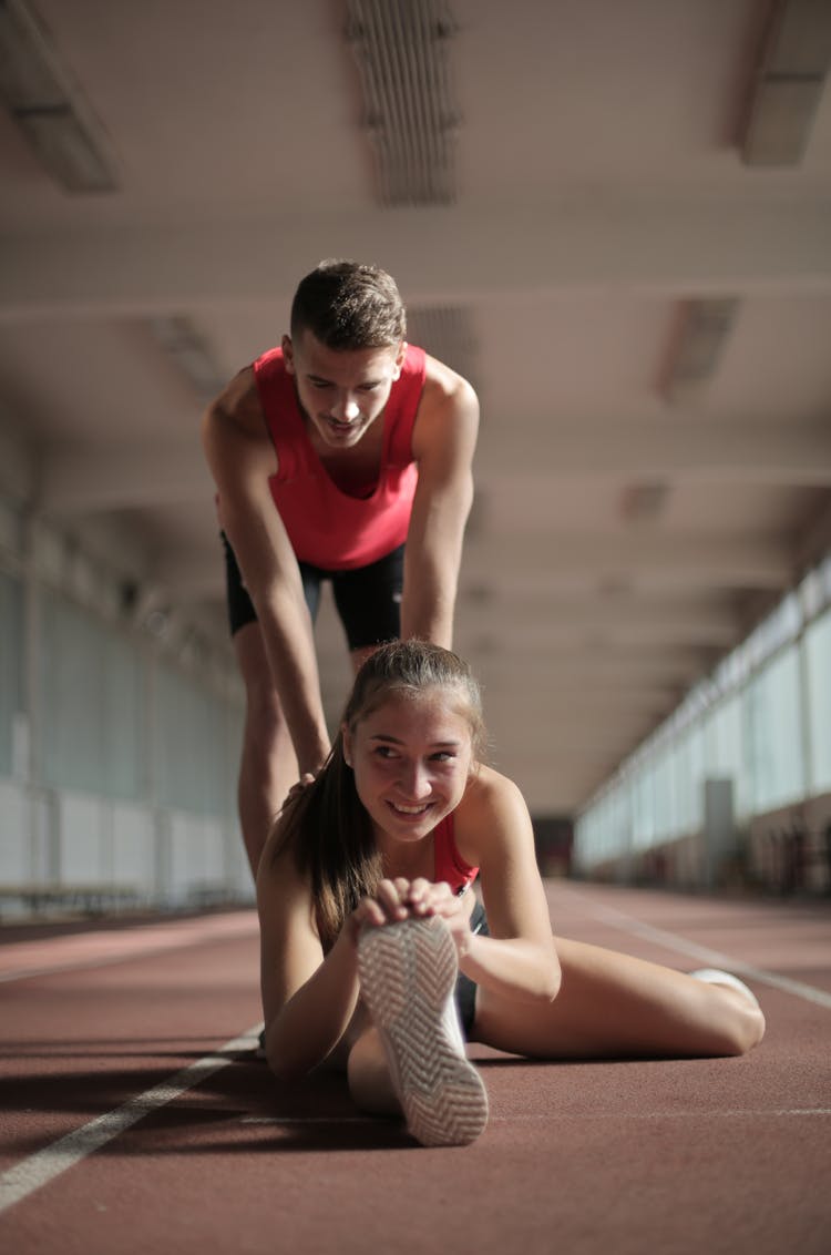 Photo Of Man Helping A Woman In Stretching