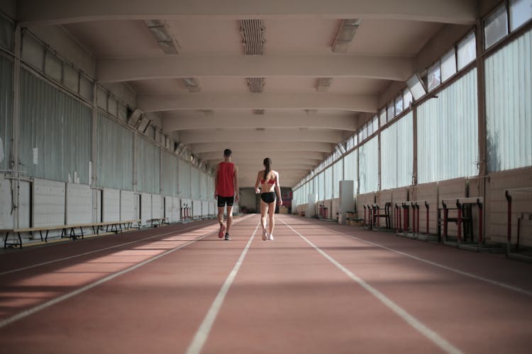 Fit Professional Athletes Walking Along Running Track