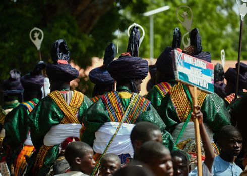 Vibrant cultural procession with traditional attire and colorful decorations.