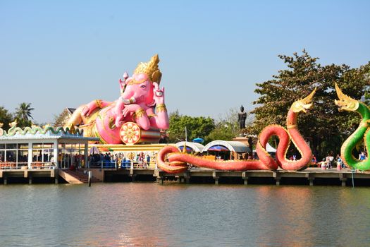 Giant Ganesh and colorful serpent statues by a lake in Tambon Bang Kaeo, Thailand.