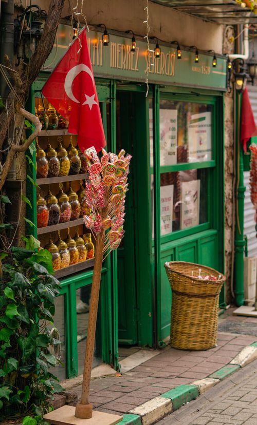Free Charming candy shop with Turkish flag in Istanbul, vibrant display of sweets and greenery. Stock Photo