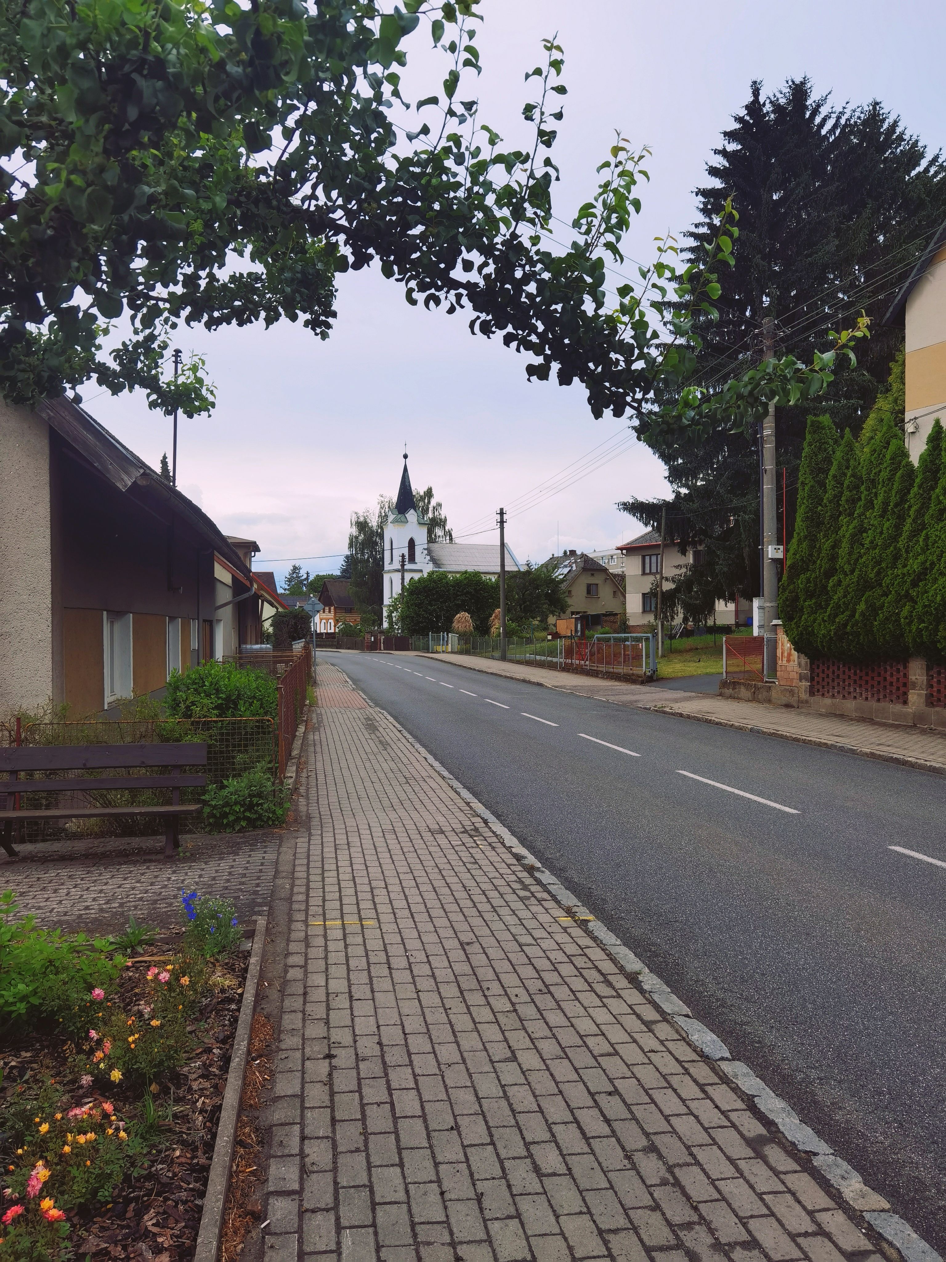 Charming street in Příšovice, Czech Republic with a church view, perfect for travel and architecture themes.