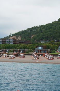 Elegant beachfront resort huts with cabanas and lush greenery, perfect for a serene getaway.
