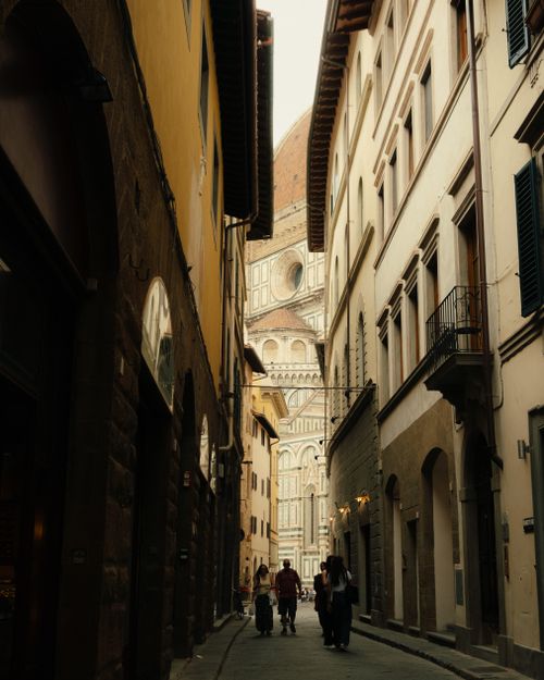 Free Charming narrow street view in Florence, Italy, with Florence Cathedral in the background. Stock Photo