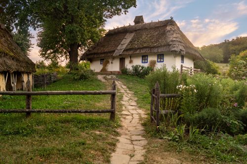 Free Charming thatched roof cottage with lush greenery in the Ukrainian countryside. Stock Photo