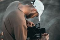 男人专注于户外视频拍摄的相机设置，展现了精度和奉献精神