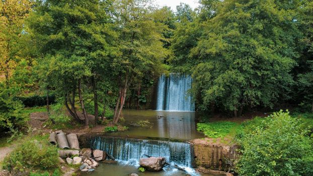 A tranquil waterfall surrounded by lush greenery, offering a serene escape to nature lovers.