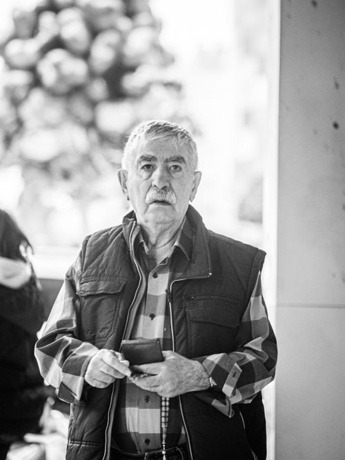 Free Candid black and white portrait of a senior man outdoors holding a phone. Stock Photo