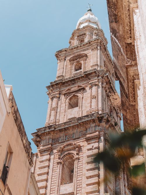 Free Stunning view of a historic bell tower in Monopoli, showcasing intricate Italian architecture under a clear sky. Stock Photo