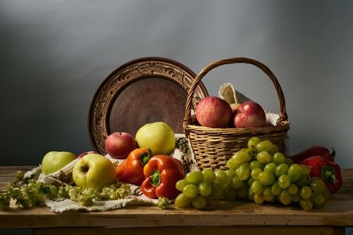 Free A beautifully arranged still life featuring apples, grapes, and peppers in a rustic setting. Stock Photo