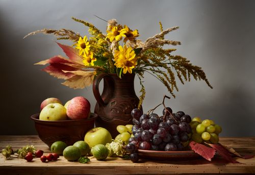 Free A rustic still life featuring autumn fruits and vibrant flowers on a wooden table. Stock Photo