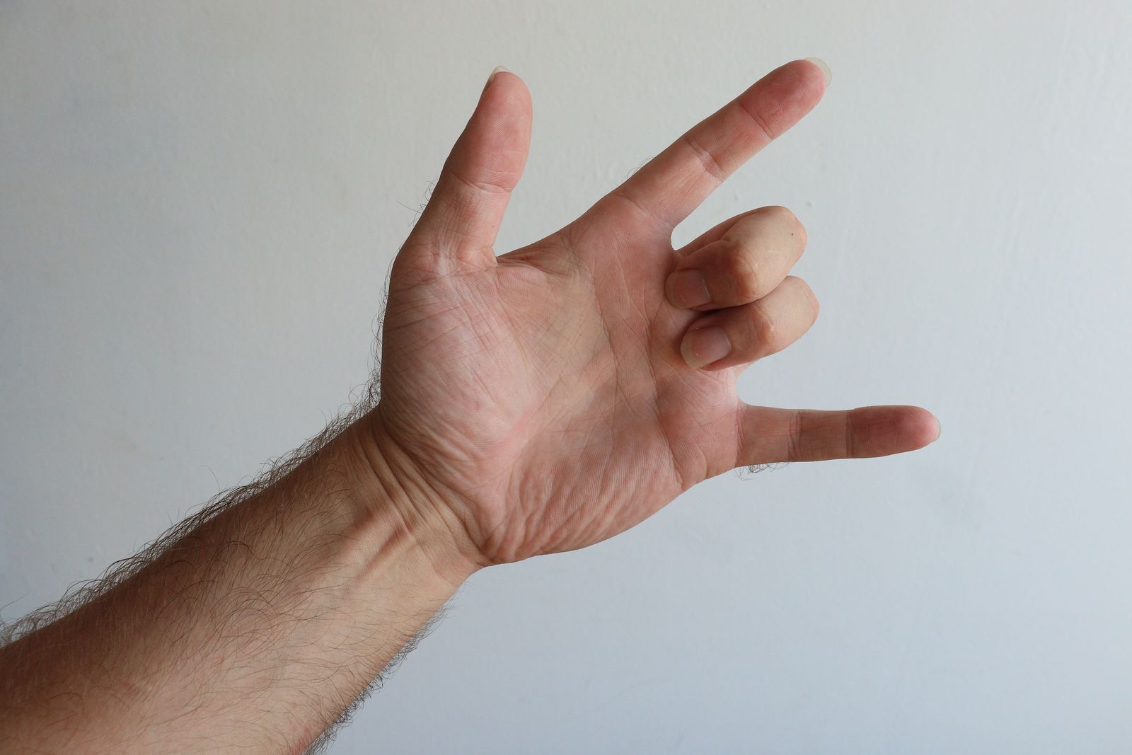Bright close-up of a person holding and checking their wrist and hand outdoors