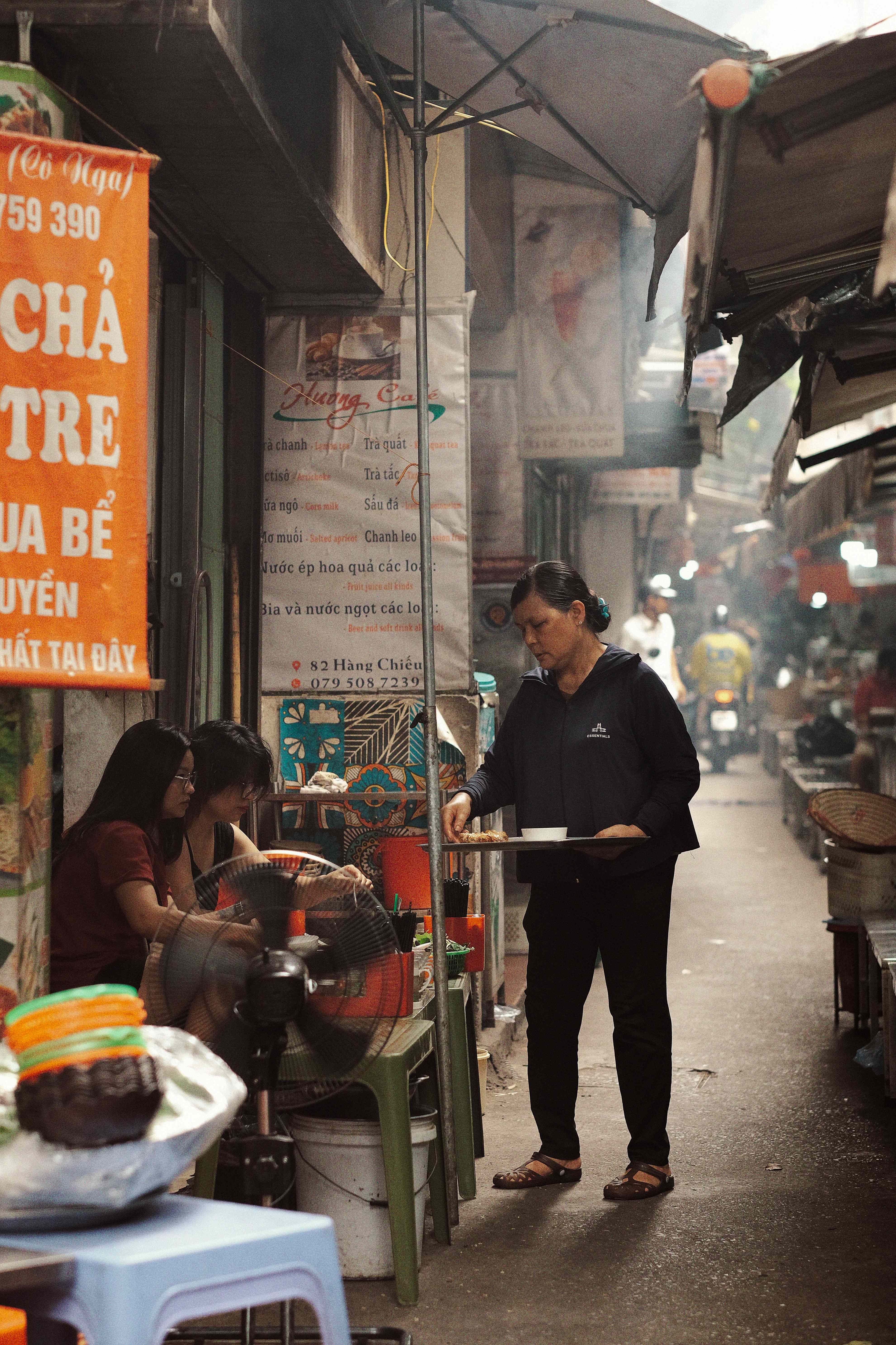A bustling street market scene in Hanoi, Vietnam showcasing daily activities and vibrant local culture.