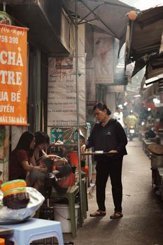 A bustling street market scene in Hanoi, Vietnam showcasing daily activities and vibrant local culture.