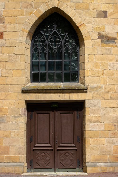 Free A gothic arched window above a wooden door on a historic building in Jönköping, Sweden. Stock Photo