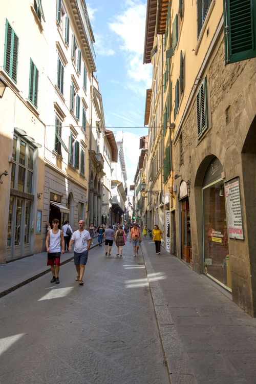 Free People walking down a vibrant street in a historic European town with classic architecture. Stock Photo