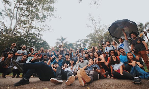 地面水平上，多民族人群聚集在绿色植物附近，看着相机