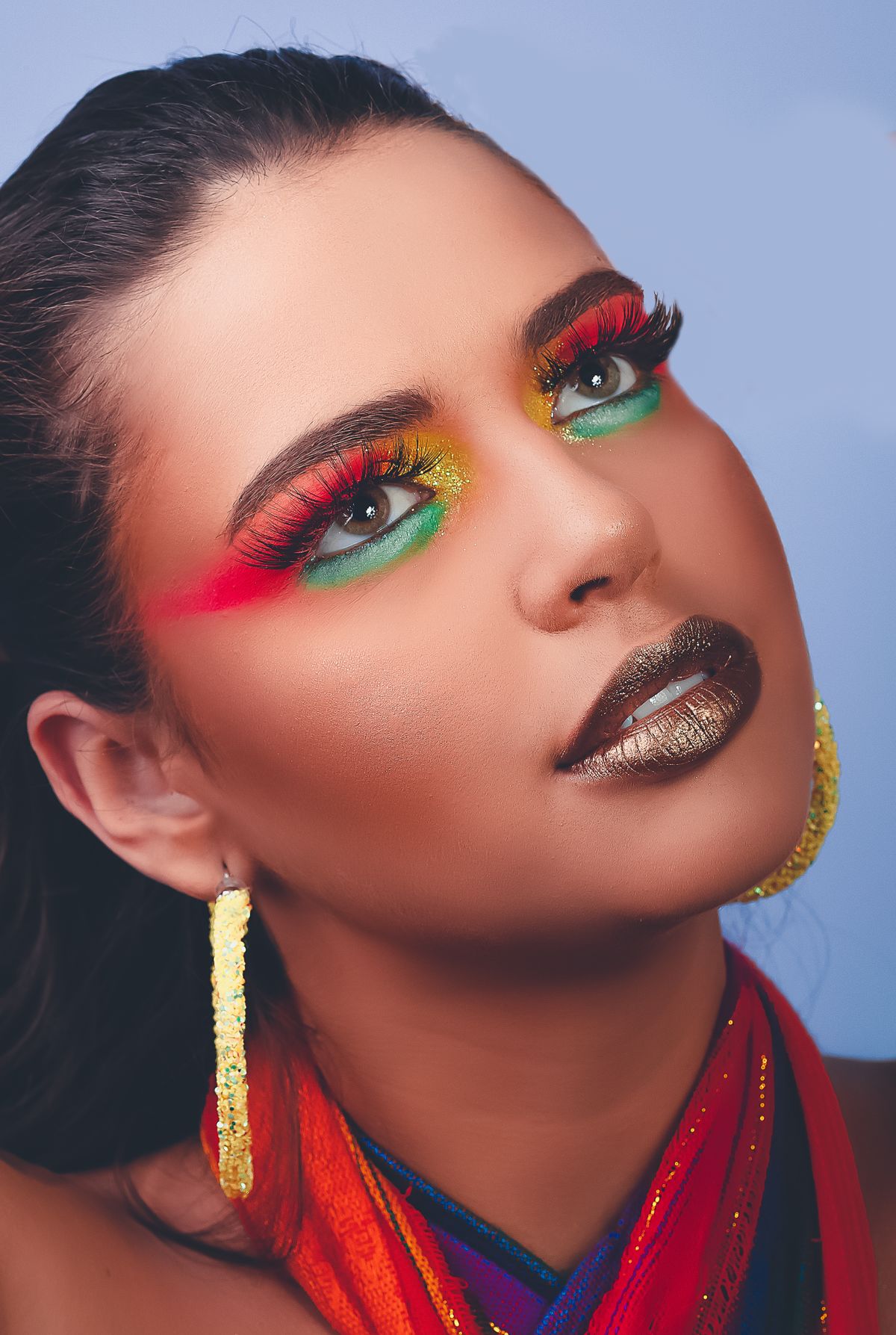 Close-up of an eye with colorful makeup and metallic accents