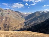 Stunning view of mountains and winding road under a blue sky, perfect for travel and nature themes.