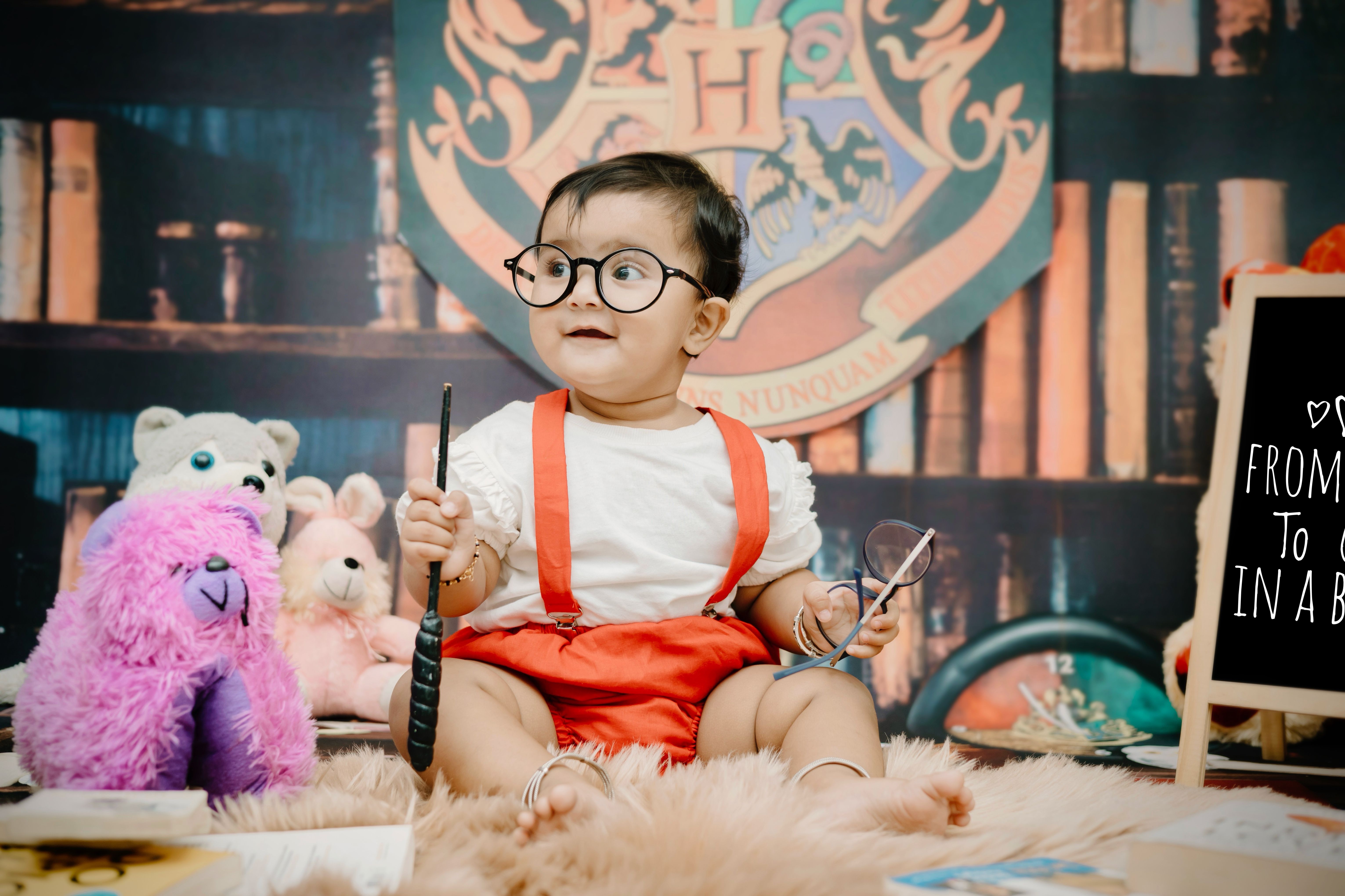 Cute baby dressed as a young wizard with a magical theme and toys. Perfect for fantasy and family fun concepts.