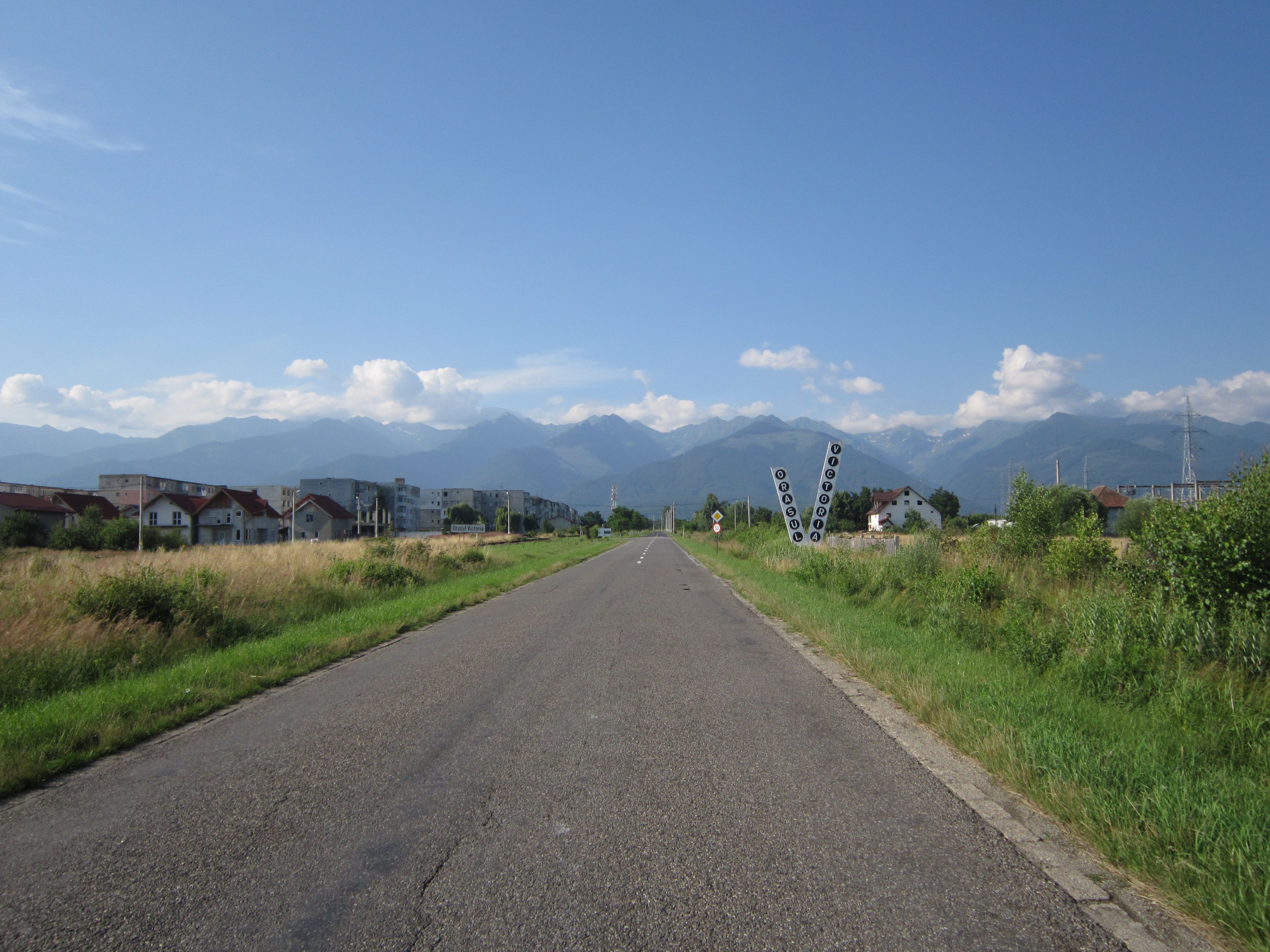 Scenic rural road with a car driving through the Romanian countryside
