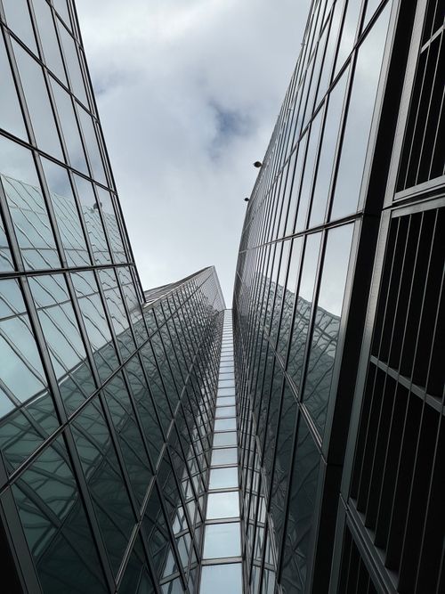 Free Tall glass skyscrapers rise towards cloudy sky in Milan, Italy. Stock Photo