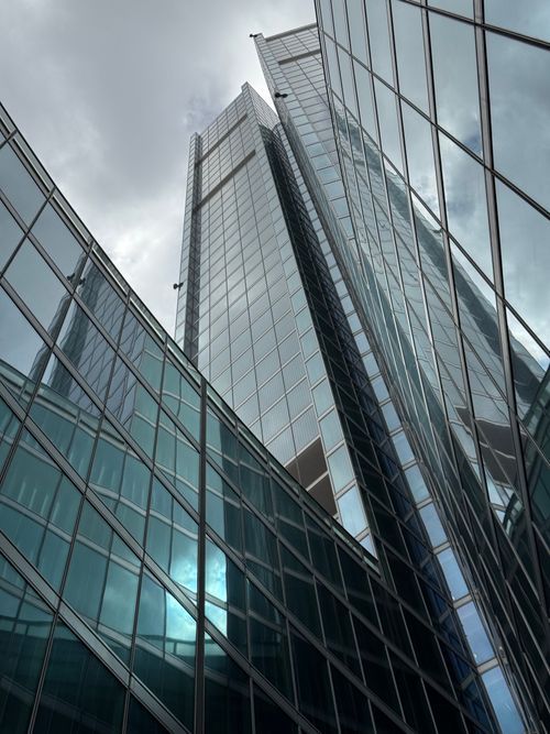 Free Tall modern skyscrapers in Milan, Italy, reflecting the cloudy sky above, showcasing contemporary architecture. Stock Photo