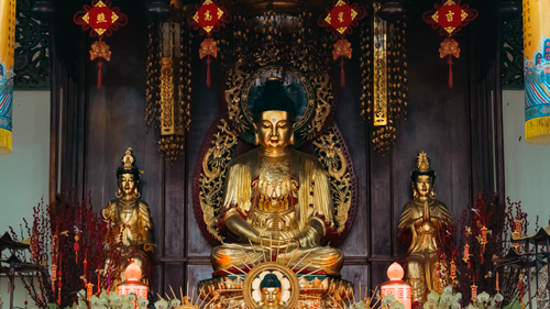 Free Intricate gold Buddha statues in ornate indoor temple setting. Stock Photo