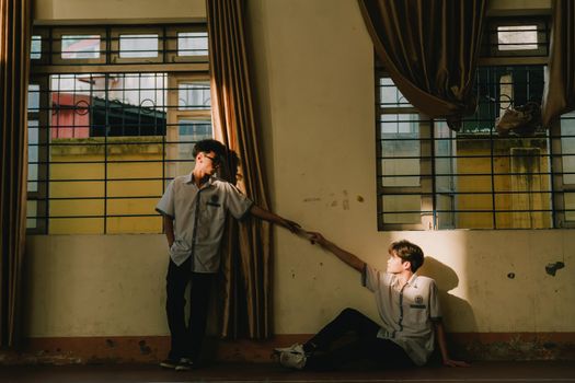Two high school students connect in a sunlit classroom.