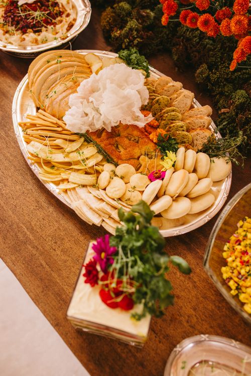 Free A beautifully arranged wedding buffet showcasing a variety of breads, cheeses, and decorative flowers. Stock Photo