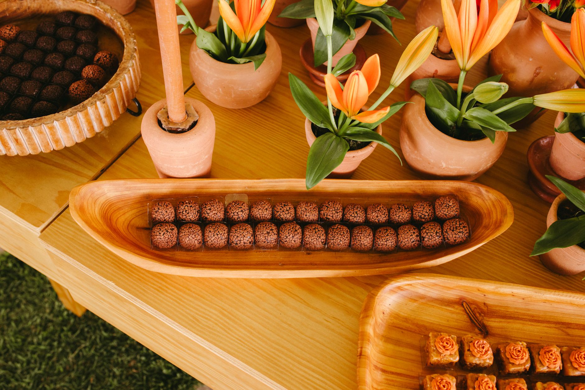 Artistic display of chocolate truffles and flowers on a wooden table, perfect for celebrations.