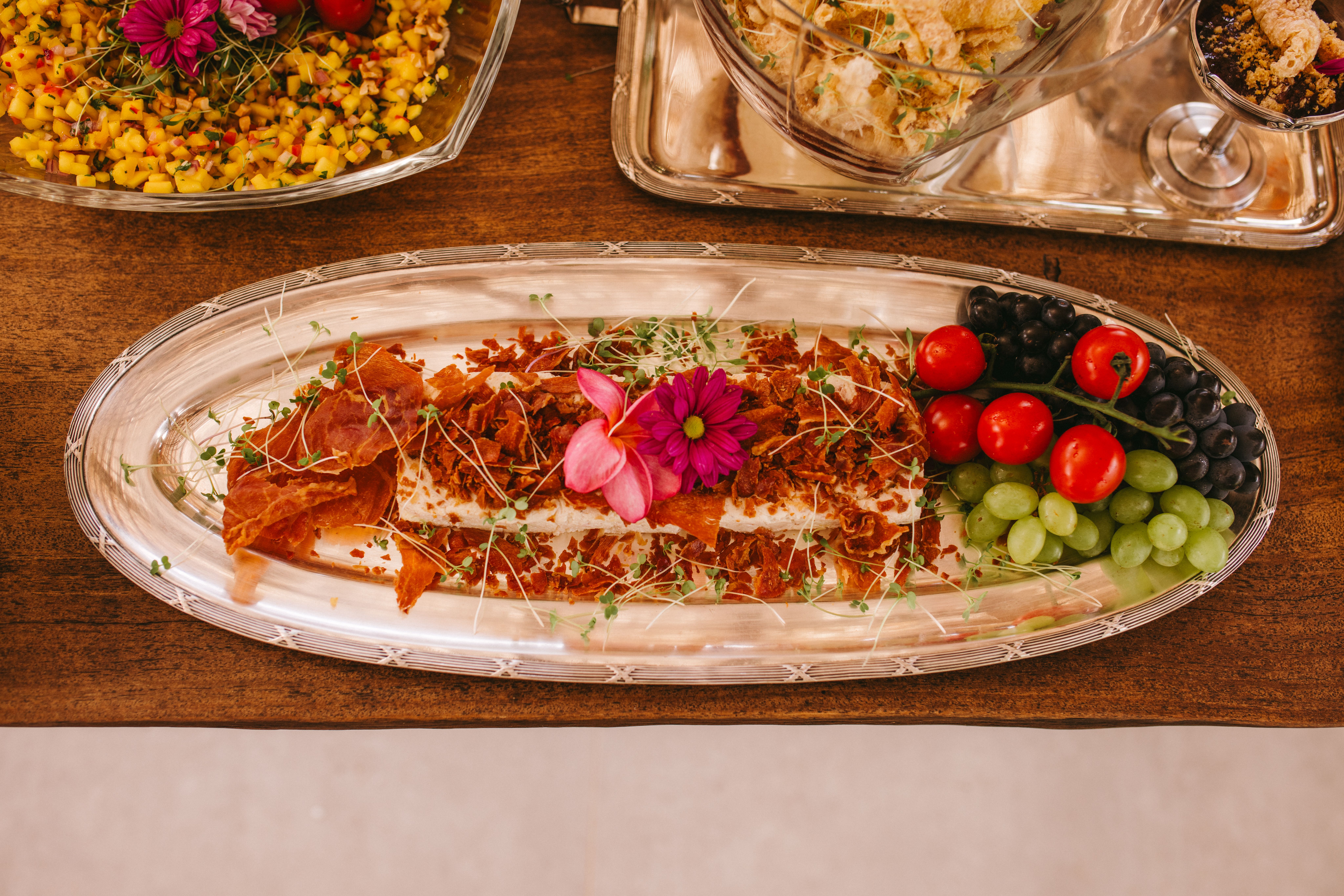 Luxury wedding food plating with fresh fruits, flowers, and decorative elements for a stylish event.