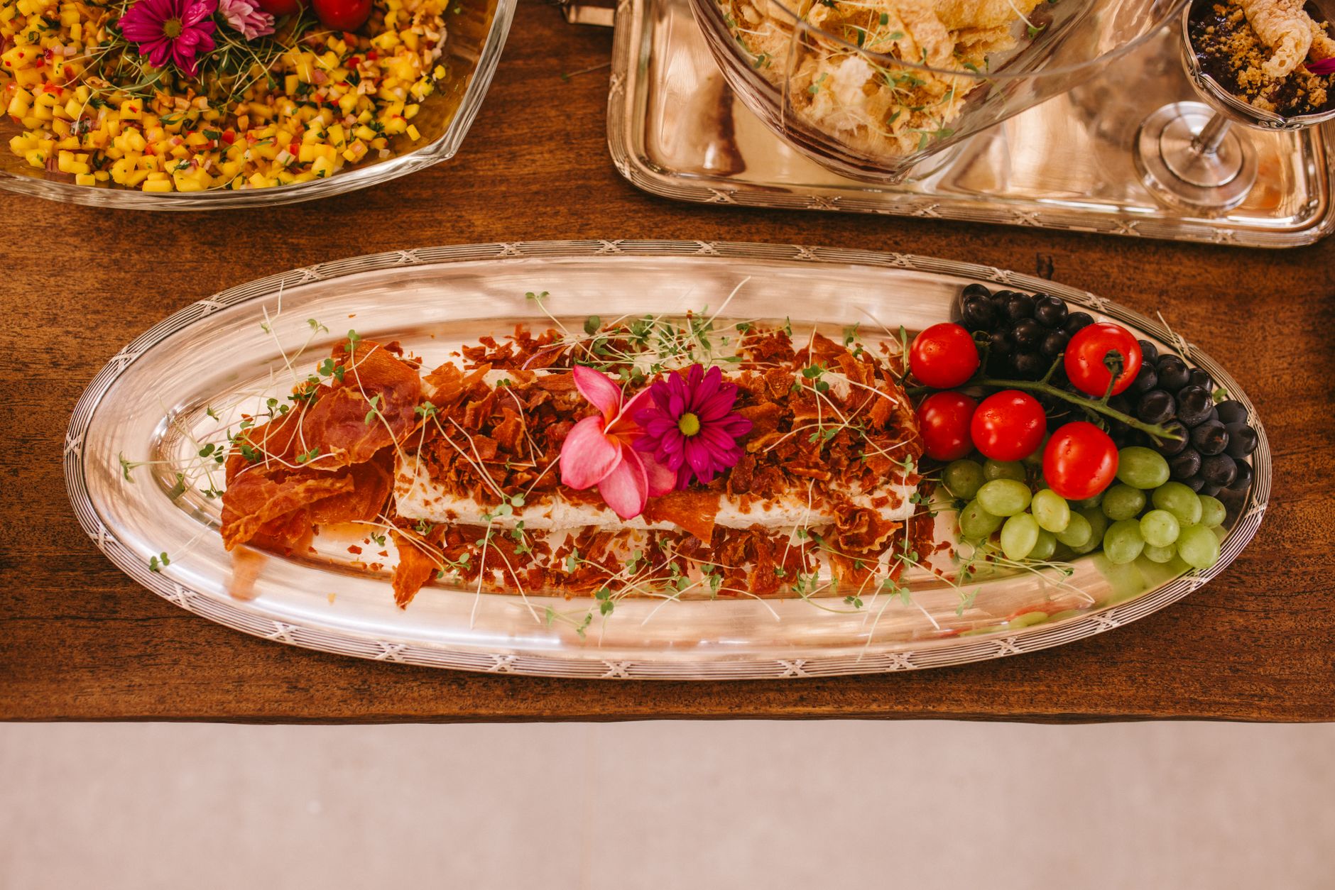 Luxury wedding food plating with fresh fruits, flowers, and decorative elements for a stylish event.