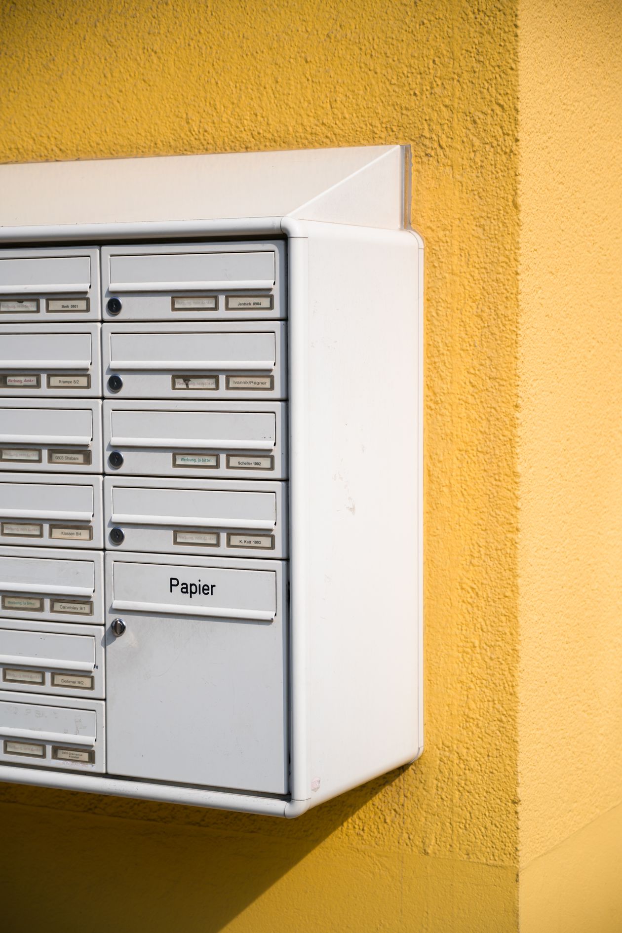 White mailboxes against a bright yellow wall representing an email list built through giveaways