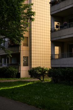 A sunlight-drenched apartment block in Berlin Marzahn with lush greenery.