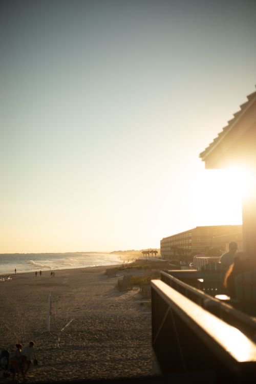 Free Serene sunset view over Folly Beach, capturing sandy shores and coastal architecture. Stock Photo