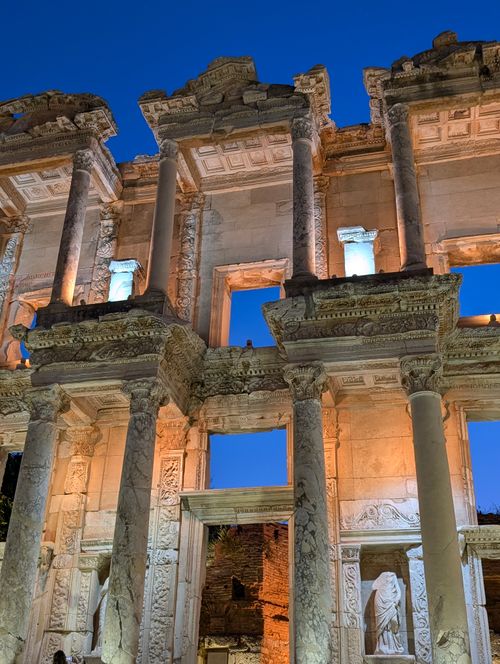 Free A stunning nighttime view of the Celsus Library ruins in Ephesus, Turkey, illuminated against a deep blue sky. Stock Photo