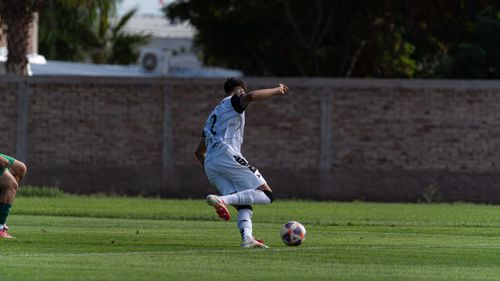 Free A soccer player in action kicking a ball during an outdoor match on a grassy field. Stock Photo