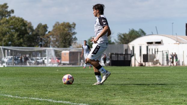 Dynamic action shot of a soccer player mid-game on a sunny day.