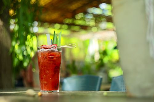 Free A vibrant strawberry cocktail with pineapple garnish on an outdoor table in sunny garden. Stock Photo
