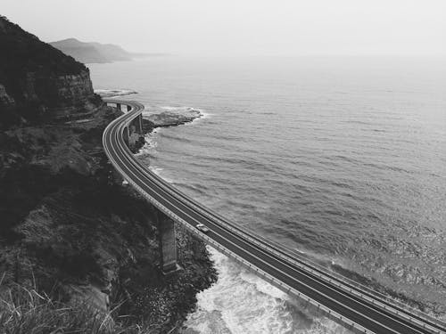 水域近くの道路のグレースケール写真